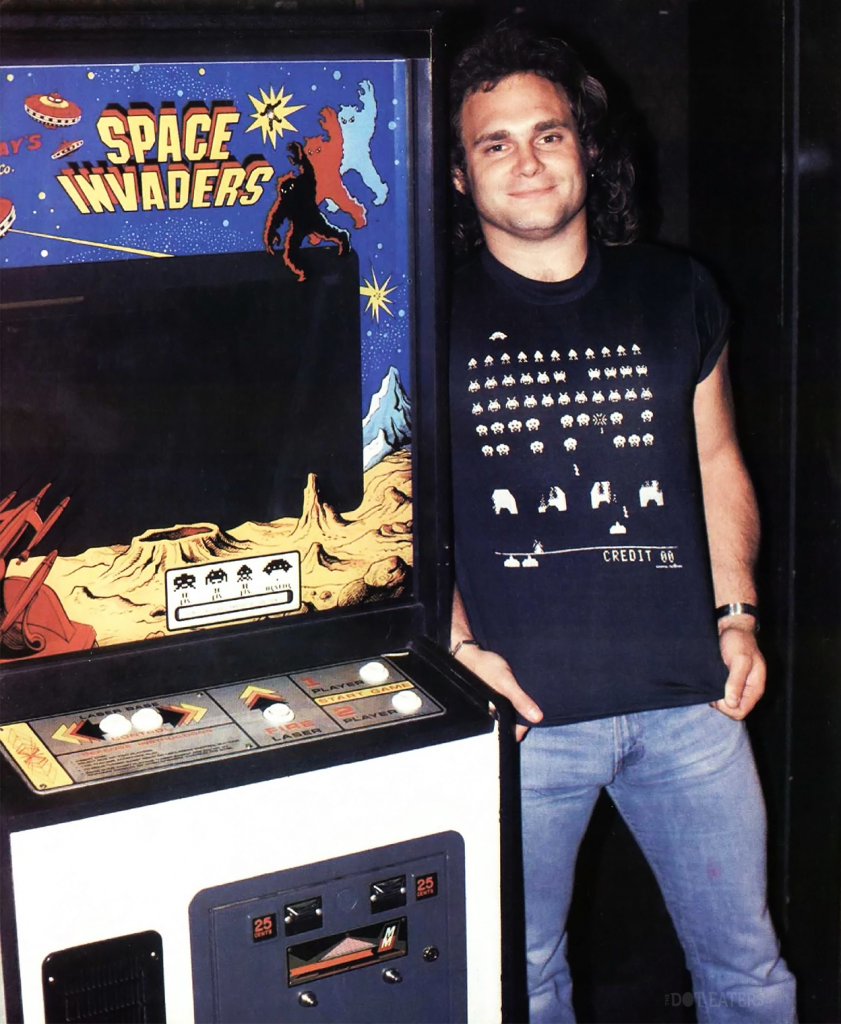 Van Halen bass player next to 'Space Invaders' machine, an arcade video game by Namco and Midway 1978